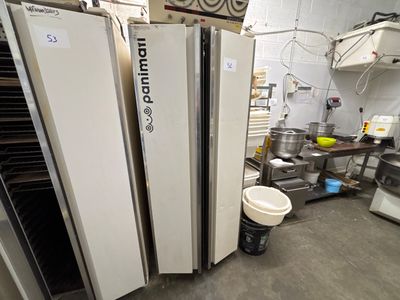 Plusieurs réfrigérateurs sont alignés dans une cuisine où se trouve un seau d'eau
