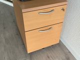 a printer on top of a filing cabinet in a room