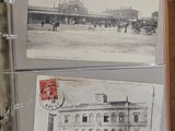 two old postcards on a desk with a lot of papers