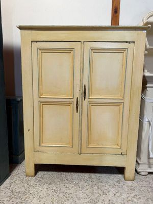 une petite armoire surmontée de deux portes