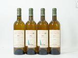 quatre bouteilles de vin sont alignées sur une surface blanche