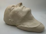 a sculpture of a man ' s head on a white surface