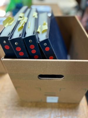 Un carton contenant quatre classeurs de feuilles et fragment…