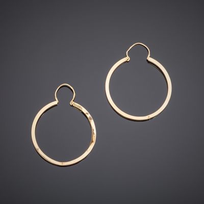 a pair of gold hoop earrings on a black background