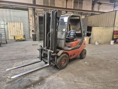 un chariot élévateur rouge garé dans un entrepôt