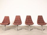 three brown leather chairs sitting in front of a white wall