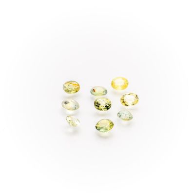 a group of yellow and green gems on a white surface