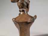 an image of a bronze statue of a woman with a hat on her head