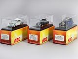 trois voitures miniatures dans une vitrine posée sur une table