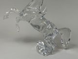 a glass horse that is sitting on its hind legs