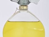 two bottles of perfume with a bird on top of them