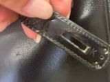 a hand that is holding a knife in a black bag