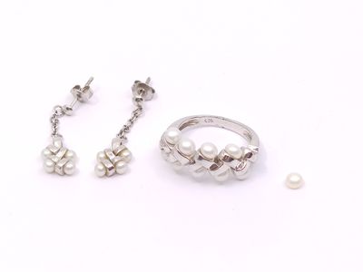 deux bagues et une paire de boucles d'oreilles posées sur une surface blanche