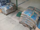bags of cement sitting on the ground next to a pile of bags