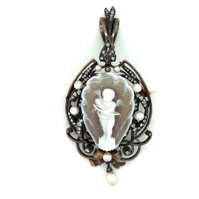 a close up of a pendant on a white background with pearls