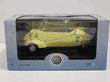 maquette jaune d'une voiture dans une boîte posée sur une surface blanche