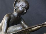 a bronze statue of a boy sitting on top of a horse