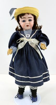 une poupée qui porte un chapeau et une robe
