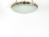 un luminaire rond en verre suspendu au plafond dans une pièce blanche