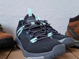 three pairs of hiking shoes sitting on top of boxes