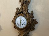une horloge accrochée au mur à côté d'un tableau