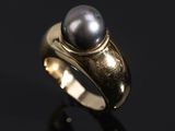 un gros plan d'une bague ornée d'une perle noire