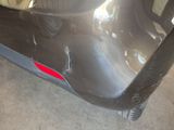 the rear bumper of a car with a red sticker on it