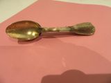 a gold spoon on a pink napkin on a table