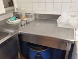 a kitchen with a sink and a trash can in it