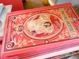 un livre rouge posé au sommet d'une pile de livres