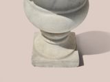 a white marble vase on a pedestal on a pink background