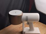 un petit objet blanc posé sur une table en bois, à côté d'une lampe