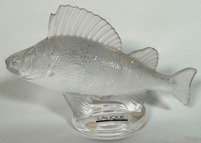 un poisson en verre posé sur un socle en verre
