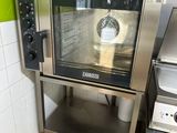un four argenté posé dans une cuisine, à côté d'une cuisinière