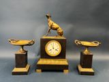 trois œuvres d'art, dont une horloge et une statue de chien