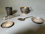 une coupe en argent, une cuillère et d'autres couverts en argent posés sur une table