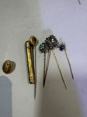 a small collection of hair pins and brooches on a table