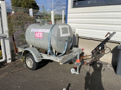 a trailer with a tank attached to it in front of a building