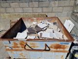 une boîte en métal rouillée contenant une pile de papiers