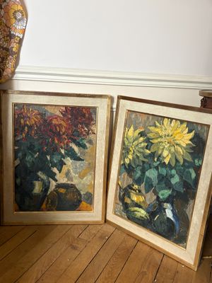 deux tableaux posés par terre, à côté d'un vase et d'un autre vase