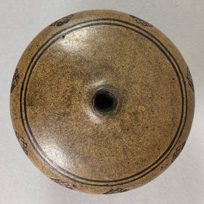 a brown vase sitting on a white surface
