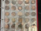 an open book with a bunch of coins in it sitting on a table