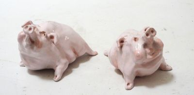 two small pink pig figurines sitting on a table