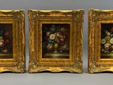 trois tableaux représentant des fleurs, dans un cadre doré, sur fond gris