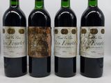 quatre bouteilles de vin sont alignées sur une surface blanche