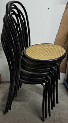 four black chairs with a wicker seat on them
