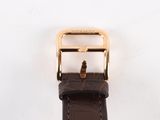 a close up of a brown leather watch strap with a gold buckle