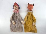 two dolls that are sitting side by side on a white surface