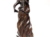 bronze statue of a woman in a dress holding a bird