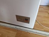 an image of a white refrigerator on a wood floor